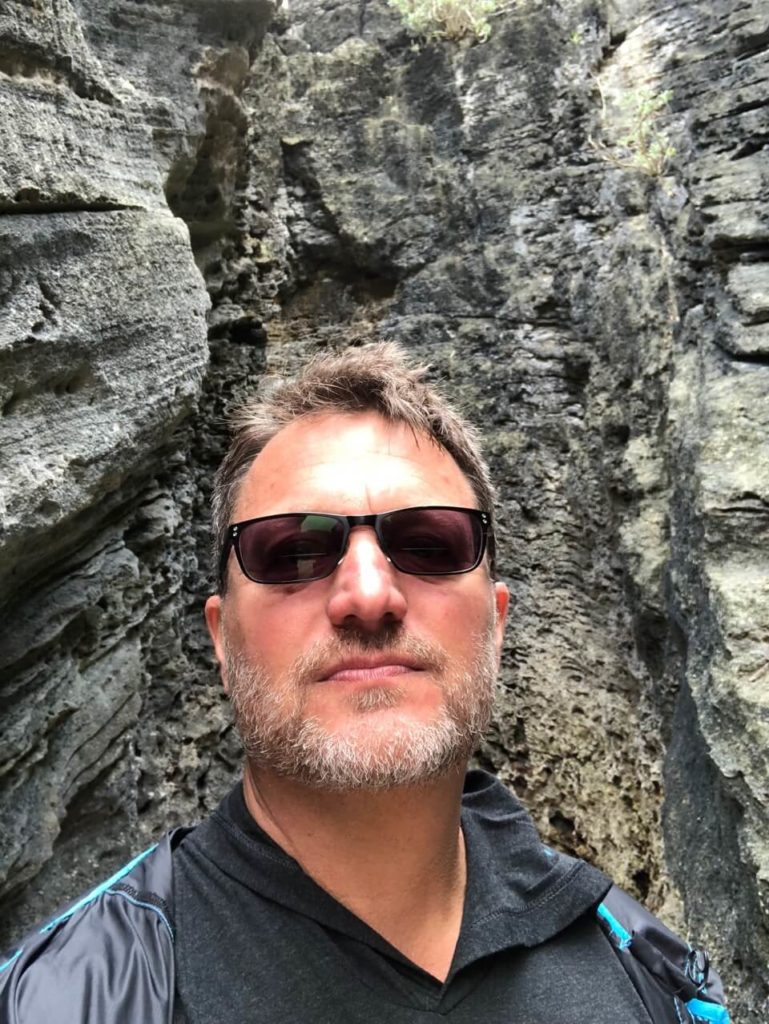 Steve meditating while standing between some rocks