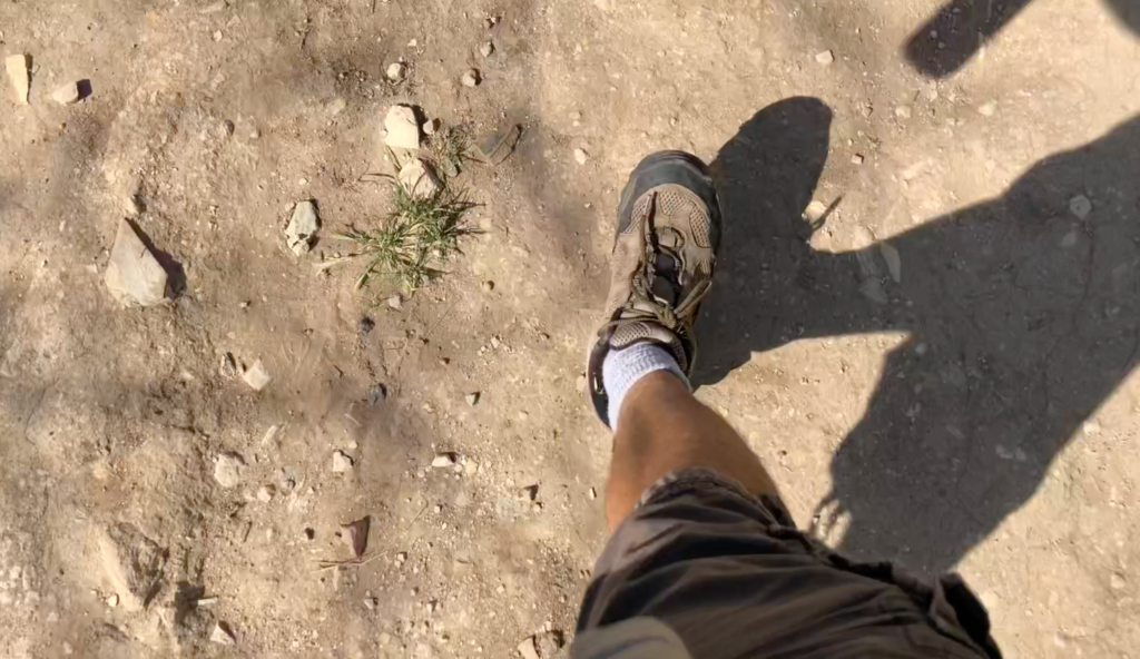 Image looking down at Steve Blum's foot in a hiking shoe while walking on a dirt path