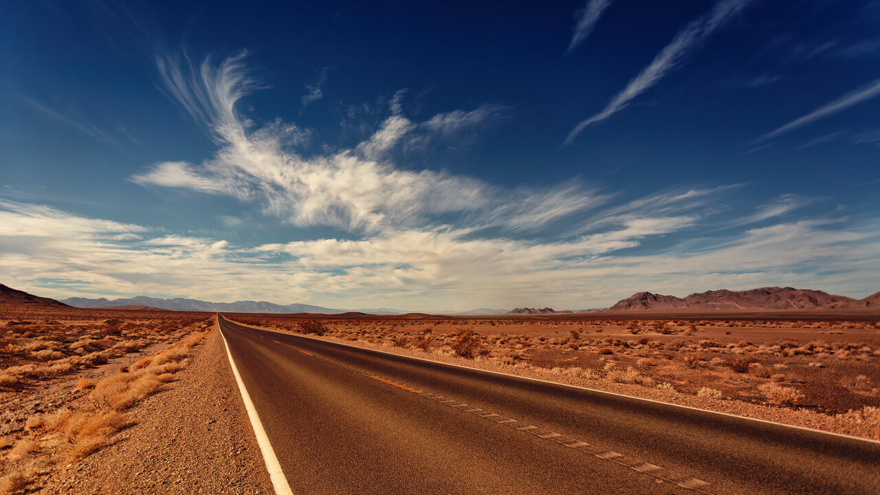 A desert road with a dark blue sky
