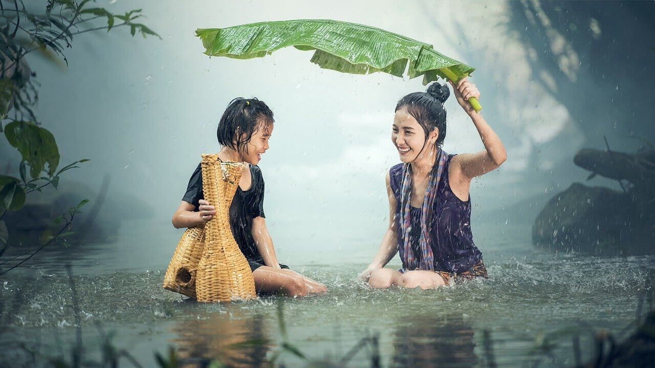 Woman and Little Girl trusting in the power of authenticity by laughing in the rain