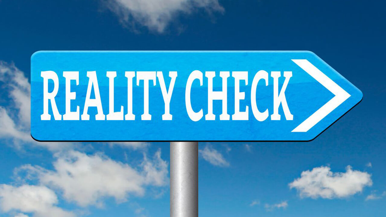 Blue sign pointing to the right and reading Reality Check in white letters