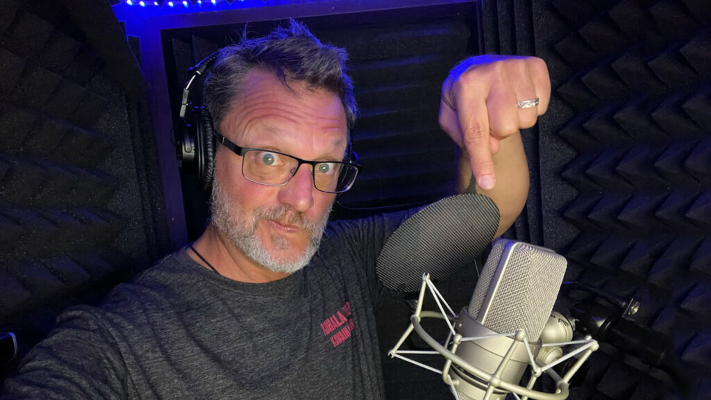 Tech and Tech- Steve Blum in the booth pointing down at his mic