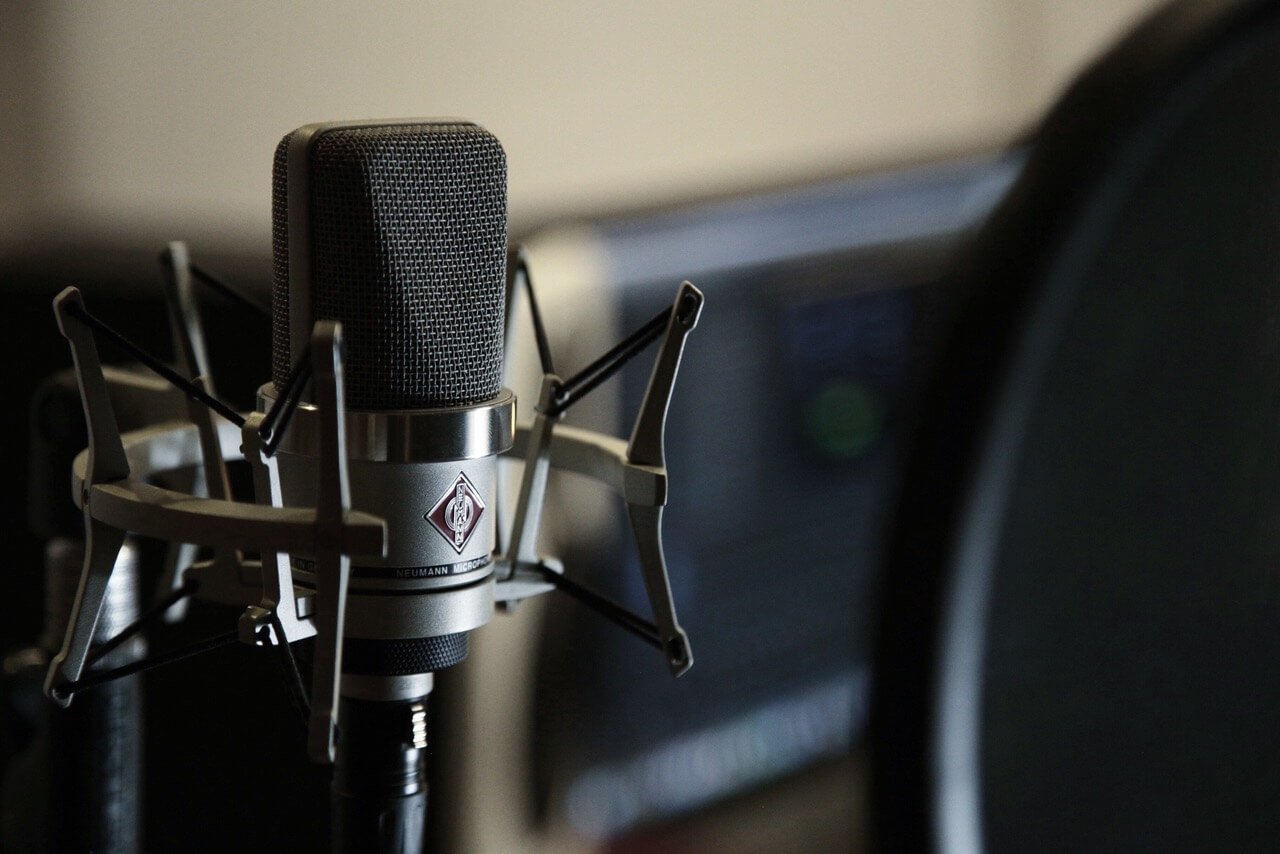 Make a Living- Close-up picture of a Neumann Microphone with a blurred desktop computer in the background