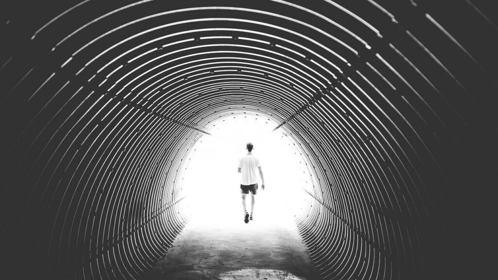Person walking out of a tunnel into the light
