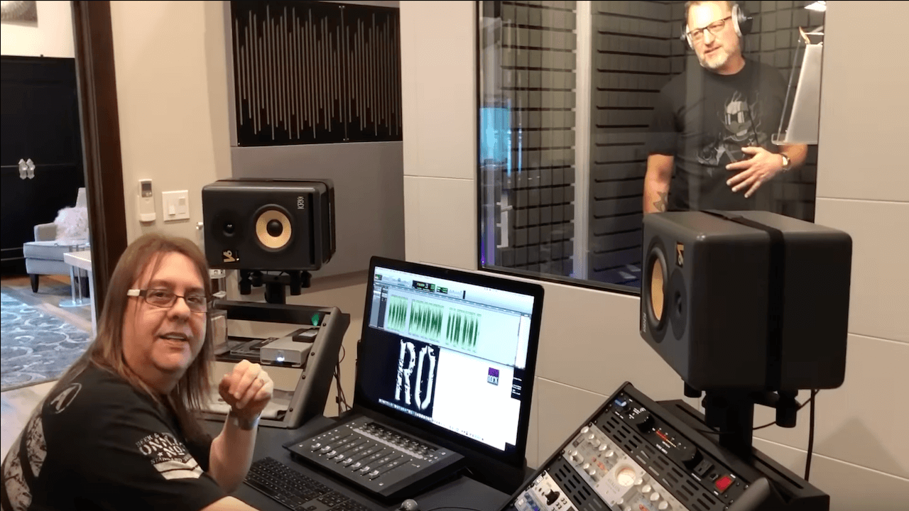 Chuck Duran speaking to the camera while sitting at a computer with Steve Blum in the recording booth